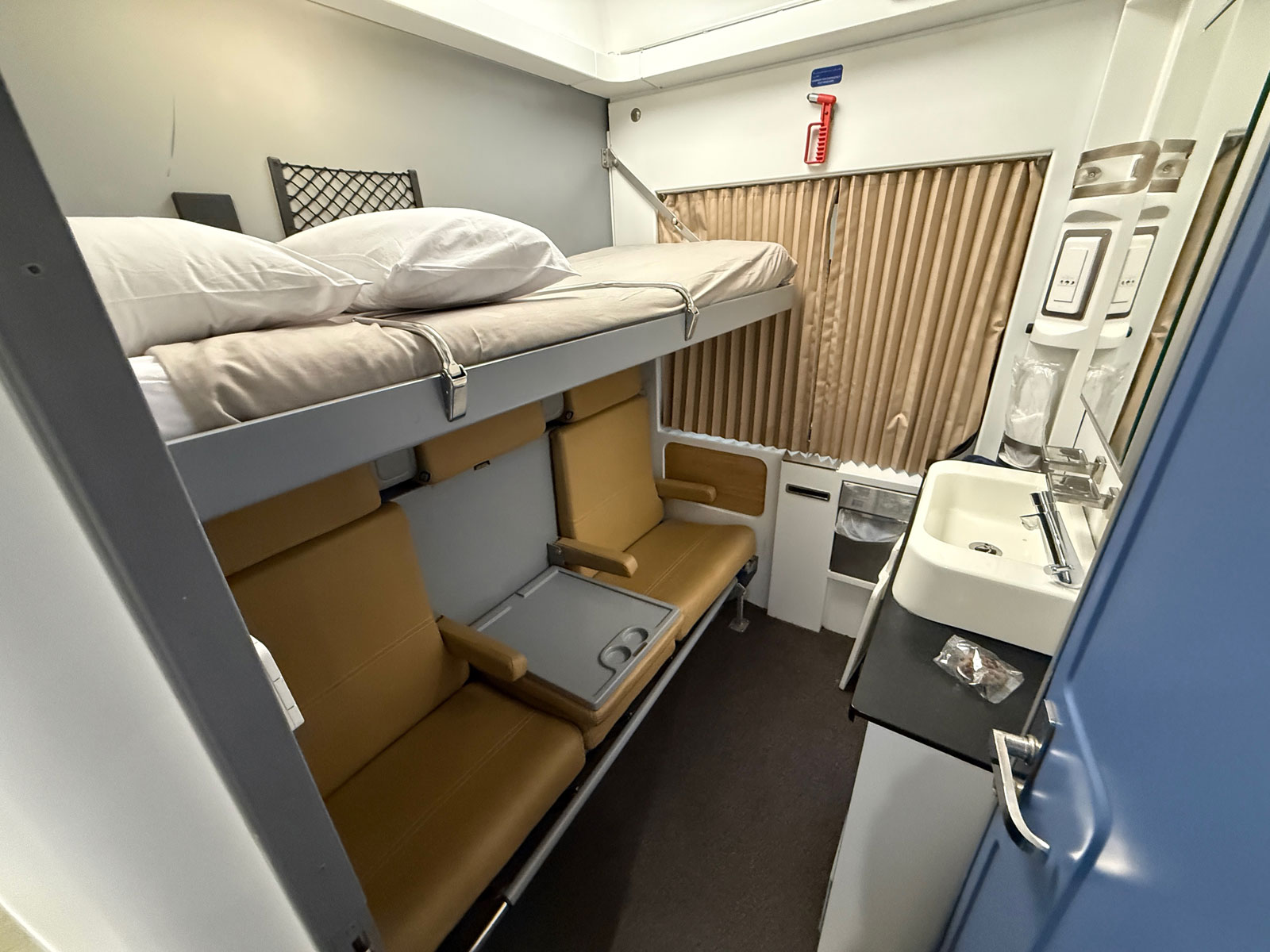Seating, fold-out table and wash basin in an Abela Elite Sleeper cabin